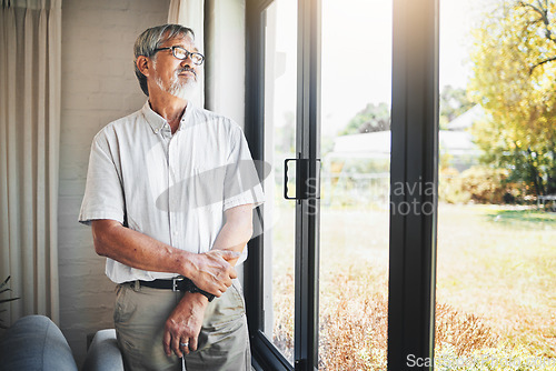 Image of Thinking, window and senior man at his home with memory, reflection or remember facial expression. Lonely, mental health and sad elderly male person in retirement by glass door in modern house.