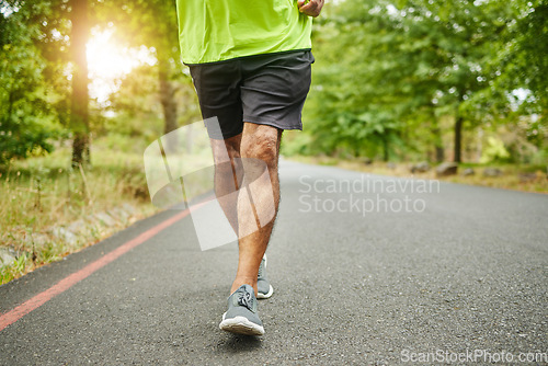 Image of Running, workout or legs of man on road, nature or forest for trekking journey or adventure for freedom. Shoes closeup, footwear or runner on street in park or woods for exercise, fitness or wellness