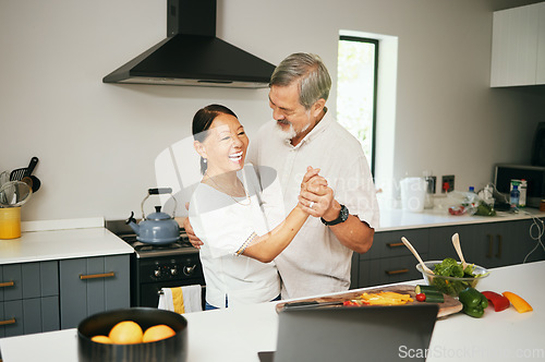 Image of Senior couple, dancing and kitchen while cooking, happiness and love at home, fun and romantic. Retirement, bonding together and smile for food, elderly and quality time with joke, retired or elderly