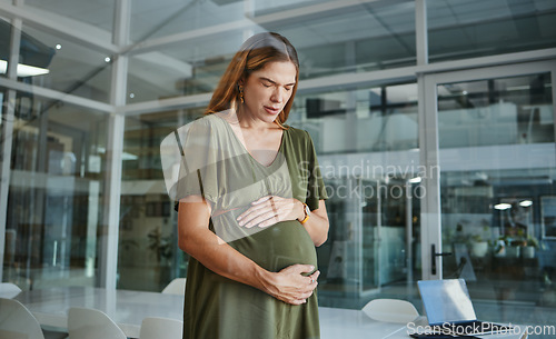 Image of Pregnancy, pain and business woman in office with contractions or muscle tension in startup company. Pregnant, discomfort and professional touch abdomen, strain and fatigue of mother in workplace