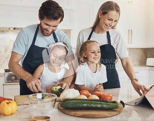 Image of Happy, cooking and family in the kitchen together for bonding and preparing dinner, lunch or supper. Love, smile and girl children cutting vegetables or ingredients with parents for a meal at home.