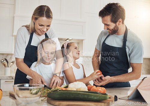 Image of Love, cooking and family in the kitchen together for bonding and preparing dinner, lunch or supper. Happy, smile and girl children cutting vegetables or ingredients with parents for a meal at home.