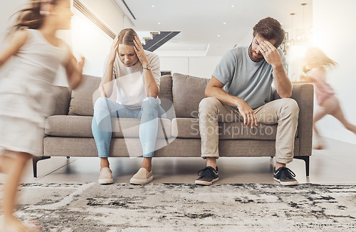 Image of Frustrated parents, sofa and headache with children running in living room chaos, ADHD or crazy home. Mother and father in stress, burnout or fatigue with busy or hyper active kids in lounge at house