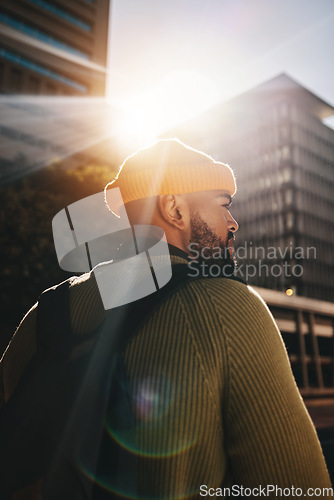 Image of Back, thinking and man in a city, fashion and lens flare with ideas, planning and decision. Person, gen z and guy outdoor, sunshine and backpack with buildings, fashion and choice with casual outfit