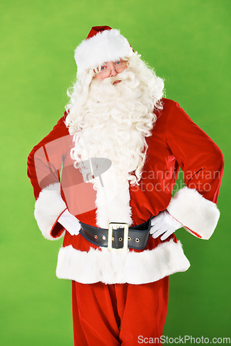 Image of Santa claus, hands and hips in studio portrait for Christmas holiday, festive season or warning. Male person, costume suit and arm gesture on green background for vacation, celebration or gift giving