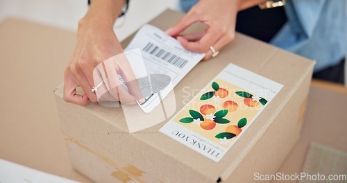 Image of Online order, delivery label and woman hand with small business sticker for cardboard box. Stock, startup process and sales of ecommerce and boutique at home of a entrepreneur with courier package