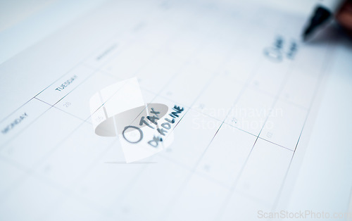 Image of Person, calendar and date for tax, deadline or reminder in schedule planning or strategy on desk at office. Closeup of writing, paper or agenda for memory, financial plan or daily tasks at workplace