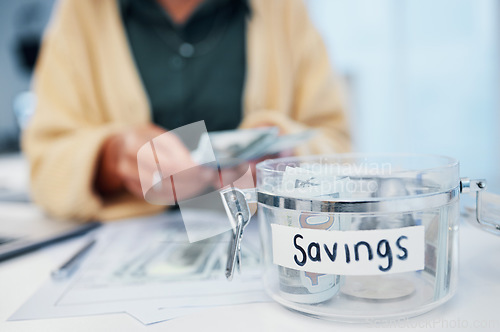 Image of Woman, jar and savings for money, investment or growth in finance, profit or expenses on desk at home. Female person counting cash, bills or paper notes in financial freedom or interest in container