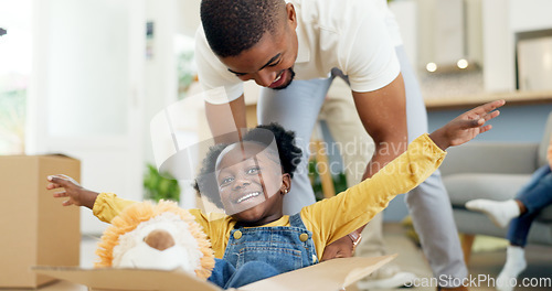 Image of Father, playing and child in a box while moving house with a black family together in a living room. Man and a girl kid excited about fun game in their new home with a smile, happiness and energy