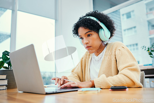 Image of Headphones, laptop and young woman typing for research in living room listening to music, playlist or album. Technology, computer and female person from Colombia streaming song on radio for studying.