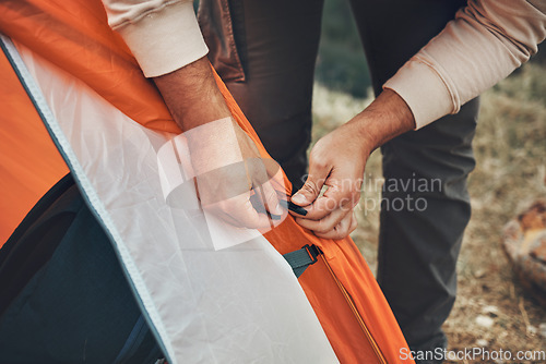 Image of Hands, pitch tent and camping in nature on vacation, holiday or travel outdoor. Campsite, closeup and man set up shelter, tying and preparation for adventure, hiking or trekking in woods for freedom