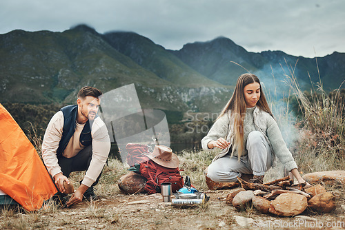 Image of Couple, camping and pitch tent in nature for vacation, holiday and travel together. Campfire, man and woman outdoor in preparation for adventure, hiking and trekking in the countryside for freedom