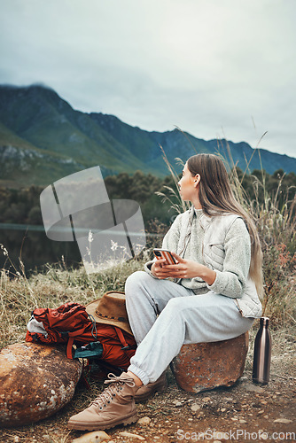 Image of Camping, phone and woman relax in nature with social media, freedom or outdoor peace. Hiking, break and female explorer with smartphone, app or chat while chilling at forest lake and enjoying scenery