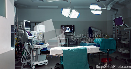 Image of Empty, dark hospital and room for operation, emergency service and healing patient. Healthcare backgrounds, surgery theatre and interior of bed, machine and medical tools for wellness, help and risk