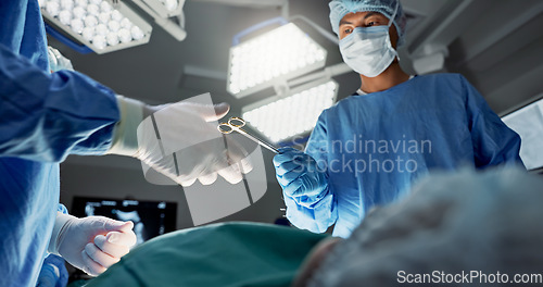 Image of Doctors, team and scissors in theater for surgery, healthcare or medical support and operation room at hospital. Surgeon, medicine and teamwork or collaboration with tools for cardiology or emergency