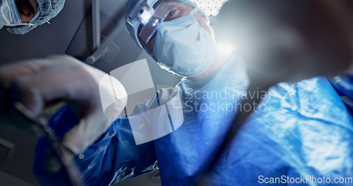 Image of Team, doctors and below in surgery, operation theater and healthcare clinic. Group, surgeon and medical tools for collaboration in emergency room, treatment of people and hands working on lens flare