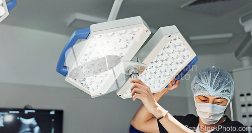 Image of Assistant, surgery and nurse with surgical light for medical emergency treatment in the hospital ER or clinic. Professional, healthcare and worker doing operation, transplant and with medicine tools