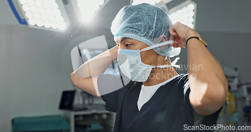 Image of Surgery, doctor and man with face mask in hospital theatre for medical service, preparation and operation. Healthcare, safety scrubs and person with uniform for emergency, procedure and protection