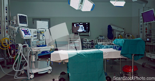 Image of Empty, dark hospital and room for operation, emergency service and healing patient. Healthcare backgrounds, surgery theatre and interior of bed, machine and medical tools for wellness, help and risk