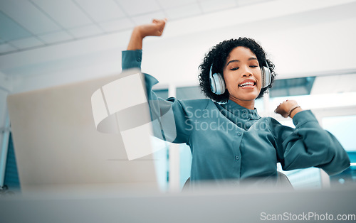 Image of Headphones, dancing and woman with laptop listening to music, playlist or album in the office. Happy, smile and female creative designer moving and streaming a song on radio on computer in workplace.
