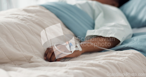 Image of Healthcare, hand and iv with a patient in a hospital bed for recovery or rehabilitation closeup. Medical, wellness and treatment with a sick person lying in a clinic on a saline solution drip