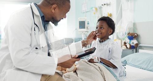 Image of Doctor, African boy kid and hospital with tablet, smile and rest for recovery from surgery, treatment or inspection. Child patient, medic and check with touchscreen, talk and rehabilitation in clinic