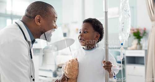 Image of Pediatrician, happy and doctor playing with child as care, support and kindness in healthcare in a hospital or clinic. Iv drip, teddy bear and African professional with medical compassion for kid