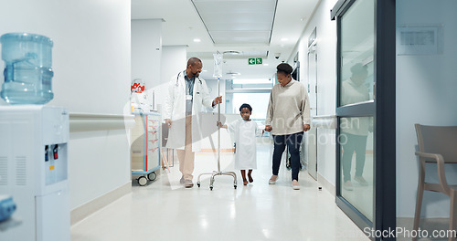 Image of Medical, pediatrician and a doctor walking with a black family in a hospital corridor for diagnosis. Healthcare, communication and consulting with a medicine professional talking to a boy patient