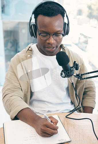 Image of Radio, podcast and black man in office writing notes for advice, questions or feedback while live streaming. Speech, presenter and African male with broadcast announcement, news or hosting talk show