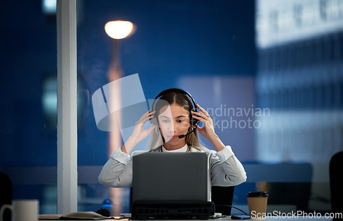 Image of Business woman, call center and headphones at night for communication, ready for telemarketing and sales in office. Professional agent, consultant or worker start job, telecom or ecommerce on laptop