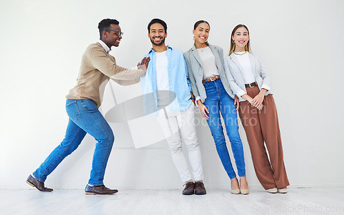 Image of Black man pushing team of business people, portrait and smile in office together for synergy. Strong professional support group of employees, solidarity for collaboration and cooperation in startup