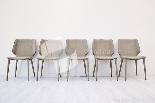 Image of Interview, empty chair and waiting room by wall background in office and hiring for job. Human resources, furniture and seating area for recruitment, minimalist and advertising vacancy or position