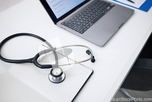 Image of Stethoscope, laptop and desk for healthcare background, medical research and hospital services or planning. Computer, heart equipment and clinic information, cardiology or telehealth in empty office