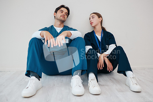 Image of Nurses, serious couple and relax in hospital, talking and communication. Medical workers, man and woman on break, conversation and healthcare team bonding, support and connection for love in clinic