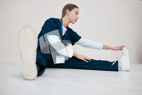 Image of Hospital, medical and a nurse stretching on the floor of a studio, getting ready for healthcare or treatment. Legs, warm up and a confident young volunteer or medicine professional on mock up