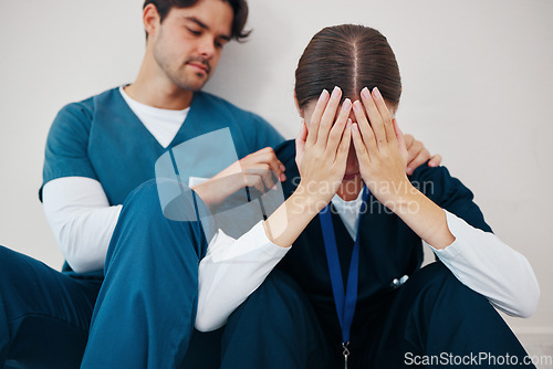 Image of Crying doctors, hospital floor and woman with man, support or empathy for regret, death or fail in surgery. Medic, partnership and burnout with depression, mistake or anxiety for healthcare in clinic