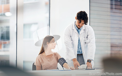 Image of Doctor, woman and blood pressure machine for hypertension, health assessment or check up at hospital. Healthcare, professional or person with monitor, digital equipment or exam for wellness at clinic