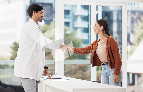 Image of Doctor, woman and handshake or meeting at hospital or medical office for introduction, welcome or thank you. Healthcare worker shaking hands with young patient for advice, help or clinic consultation