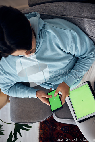 Image of Phone, green screen and a man playing games on a sofa in the living room of his home from above. Tablet, gaming and young gamer using a display or screen with tracking markers for entertainment