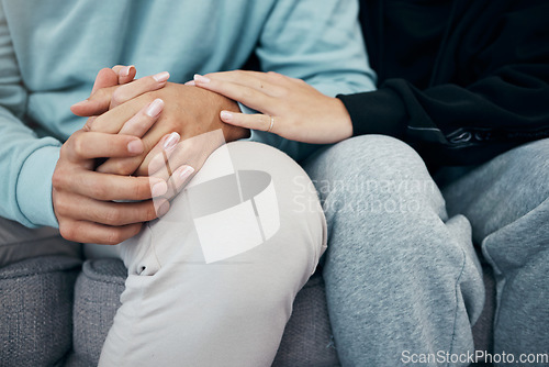 Image of Empathy, holding hands and closeup of couple on a sofa with support, love or trust in their home. Hope, kindness and zoom on people touching in a living room with solidarity, respect or grief comfort