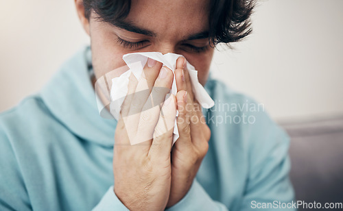 Image of Man, sick and couch with tissue, sickness and virus for infection, sinus and cold symptoms. Sneeze, blowing nose and allergy in living room sofa, hayfever and healthcare for disease, fever or alone