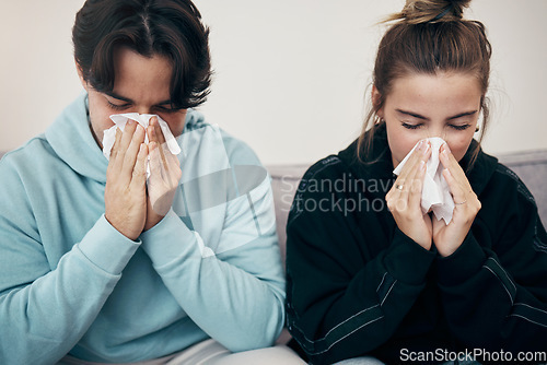 Image of Couple, sick and couch with tissue, sickness and virus for infection, sinus and cold symptoms. Sneeze, blowing nose and allergy in living room sofa, hayfever and healthcare for disease, man and woman