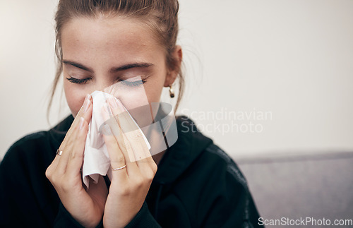 Image of Woman, sick and couch with tissue, sickness and virus for infection, sinus and cold symptoms. Sneeze, blowing nose and allergy in living room sofa, hayfever and healthcare for disease, fever or alone