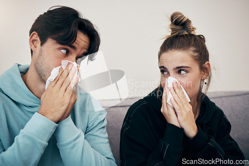 Image of Couple, sick and virus with tissue, sofa and sickness for infection, sinus and cold symptoms. Sneeze, blowing nose and allergy in living room couch, hayfever and healthcare for disease, man and woman