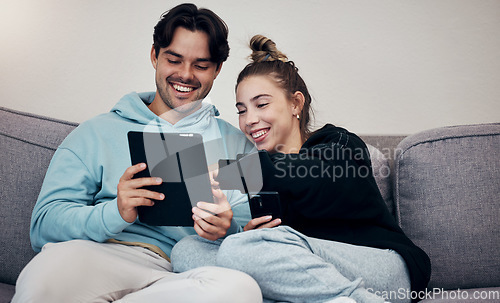 Image of Couple, phone and tablet with laugh on sofa for social media, internet scroll and funny meme with relax. People, man or woman on couch with smartphone and touchscreen for technology and web streaming