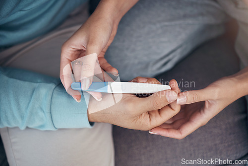 Image of Couple, hands and holding of pregnancy test in closeup for family planning, future and love on sofa in space. Man, woman and married with result on stick for news of fertility with support for care