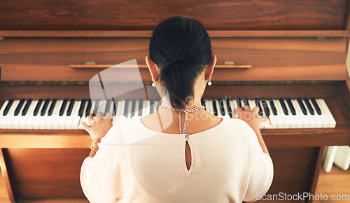 Image of Musician, piano and person playing music in home living room for artistic musical and creativity talent learning. Back view, lounge and artist practice song on keyboard as hobby with instrument