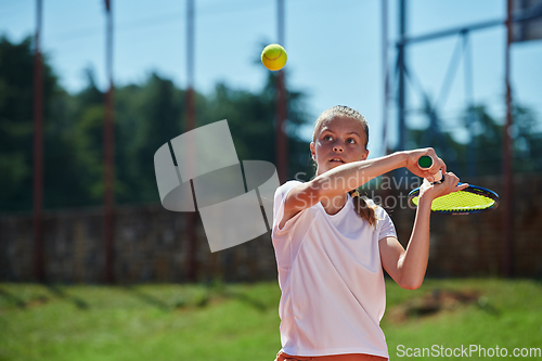 Image of A young girl showing professional tennis skills in a competitive match on a sunny day, surrounded by the modern aesthetics of a tennis court.