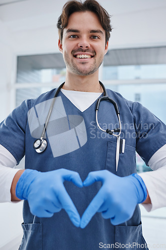 Image of Portrait, hospital and hands in heart of doctor for medicine, surgery and working in clinic for wellness. Healthcare, emoji and man with hand sign for safety, insurance or support for medical service