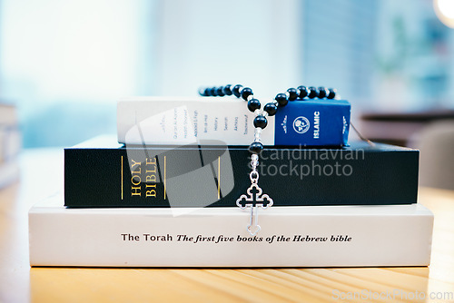 Image of Books, stack and closeup on table for faith, Abrahamic religion or rosary with crucifix for study in home. Knowledge, holy spirit and education with cross for Jesus, Muhammad or Moses with solidarity